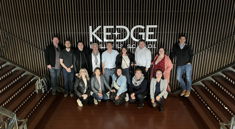 GWEMBA 4 students standing in front of Kedge Business School sign in Bordeaux, France.